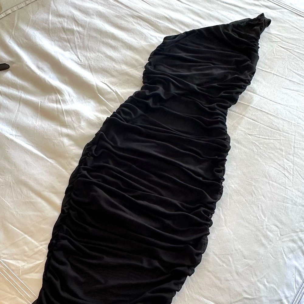 Look effortlessly stunning in this black one-shoulder House of Harlow dress. The